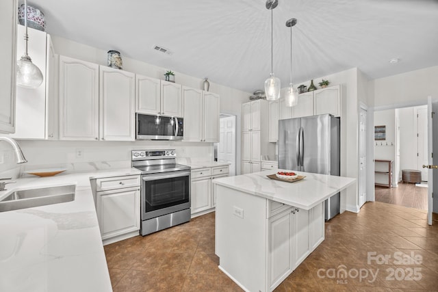 4108 Deerfield Dr NW, Concord, NC 28027 - kitchen featuring stainless steel appliances, a center island, white cabinets, dark tile patterned flooring, and pendant lighting