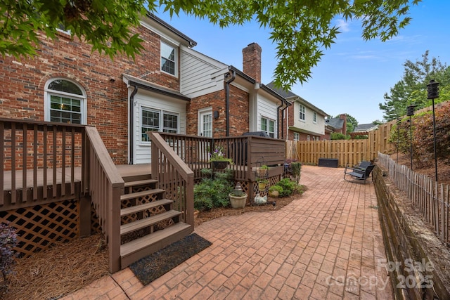4108 Deerfield Dr NW, Concord, NC 28027 - back of property with a deck, a fenced backyard, a chimney, brick siding, and a patio