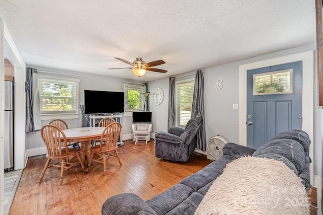 60 37th St NW, Hickory, NC 28601 - living room featuring a textured ceiling, light wood finished floors, a ceiling fan, and healthy amount of natural light