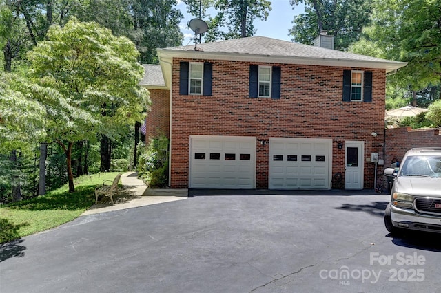 209 Camellia Way, Hendersonville, NC 28739 - view of front of house featuring a chimney, asphalt driveway, an attached garage, and brick siding