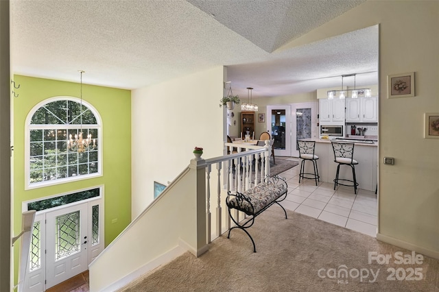 209 Camellia Way, Hendersonville, NC 28739 - corridor with a chandelier, an upstairs landing, a textured ceiling, light colored carpet, and light tile patterned floors