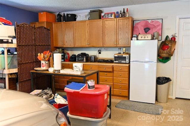 209 Camellia Way, Hendersonville, NC 28739 - kitchen with freestanding refrigerator, stainless steel microwave, light tile patterned floors, and brown cabinetry