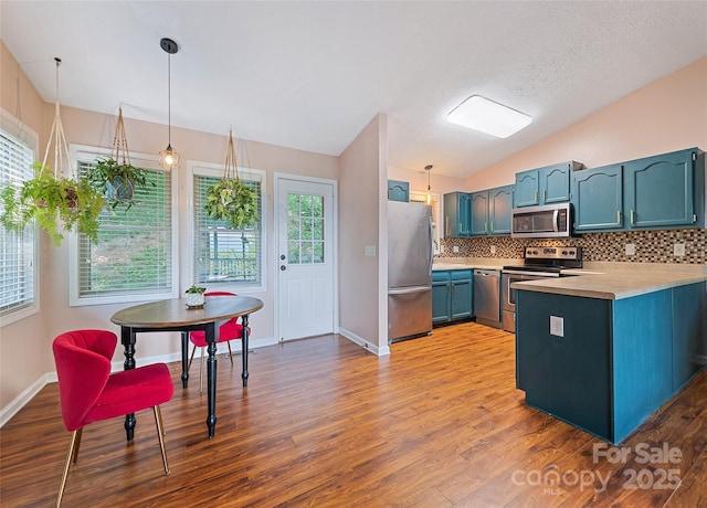 208 Tuckaway Rd, Waynesville, NC 28785 - kitchen featuring appliances with stainless steel finishes, light countertops, a peninsula, lofted ceiling, and wood finished floors