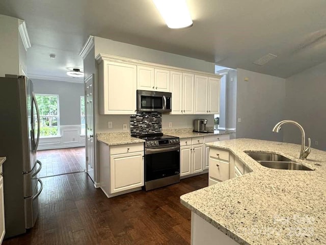 7563 Sedgebrook Dr W, Stanley, NC 28164 - kitchen with stainless steel appliances, dark wood-type flooring, light stone counters, ornamental molding, and white cabinets