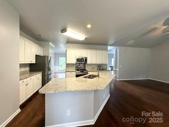 7563 Sedgebrook Dr W, Stanley, NC 28164 - kitchen featuring appliances with stainless steel finishes, dark wood-type flooring, light stone countertops, white cabinetry, and recessed lighting