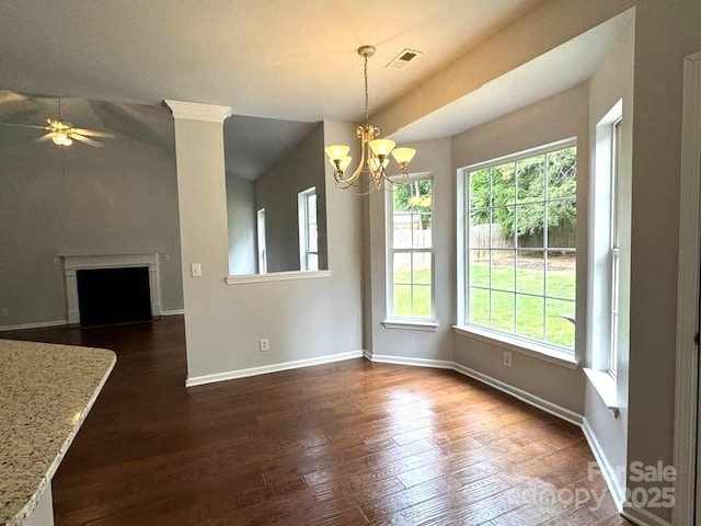 7563 Sedgebrook Dr W, Stanley, NC 28164 - unfurnished dining area featuring ceiling fan, a chandelier, dark wood-style flooring, vaulted ceiling, and a fireplace