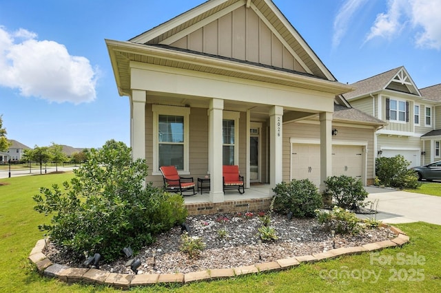 2026 Union Grove Ln, Indian Trail, NC 28079 - view of front of house with covered porch, board and batten siding, concrete driveway, an attached garage, and a front yard