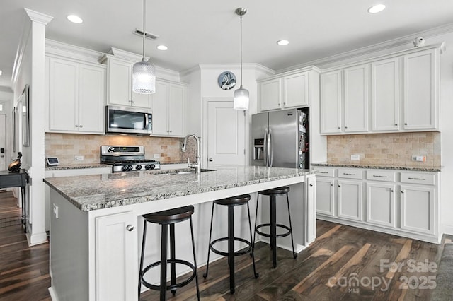 2026 Union Grove Ln, Indian Trail, NC 28079 - kitchen featuring stainless steel appliances, white cabinetry, dark wood finished floors, a breakfast bar area, and a center island with sink