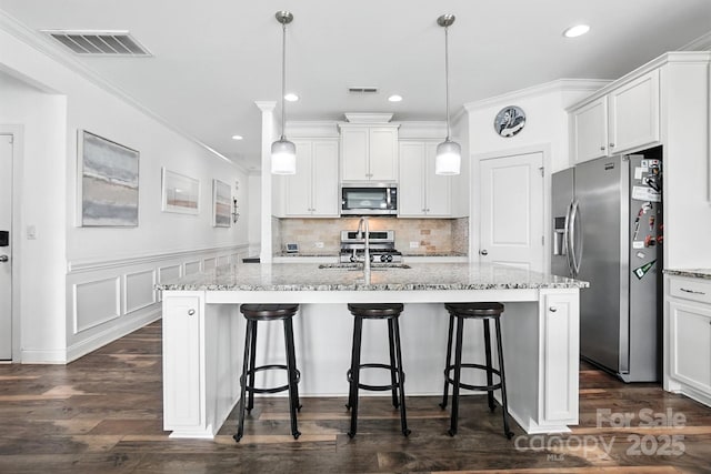 2026 Union Grove Ln, Indian Trail, NC 28079 - kitchen featuring stainless steel appliances, white cabinets, crown molding, a breakfast bar, and light stone counters
