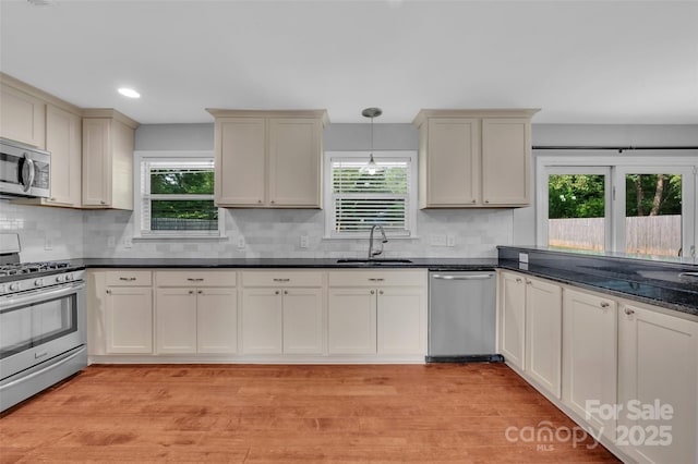 1940 Tyvola Rd, Charlotte, NC 28210 - kitchen featuring appliances with stainless steel finishes, dark countertops, healthy amount of natural light, light wood-style flooring, and recessed lighting