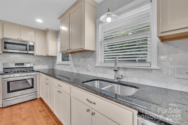 1940 Tyvola Rd, Charlotte, NC 28210 - kitchen with appliances with stainless steel finishes, backsplash, dark stone counters, light wood finished floors, and recessed lighting