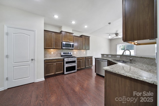 10328 Ebbets Rd, Charlotte, NC 28273 - kitchen featuring stainless steel appliances, dark wood-type flooring, light stone counters, decorative backsplash, and a ceiling fan