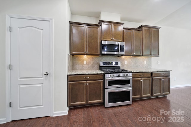 10328 Ebbets Rd, Charlotte, NC 28273 - kitchen with stainless steel appliances, decorative backsplash, light stone counters, and dark wood-type flooring