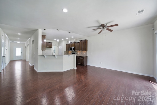 10328 Ebbets Rd, Charlotte, NC 28273 - unfurnished living room featuring a ceiling fan, recessed lighting, dark wood-style flooring, and arched walkways