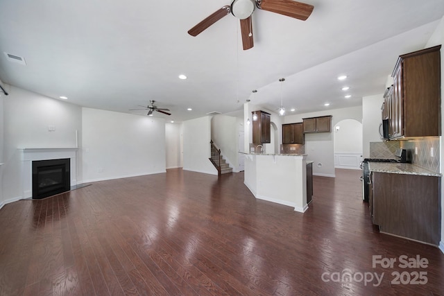10328 Ebbets Rd, Charlotte, NC 28273 - unfurnished living room featuring ceiling fan, recessed lighting, a glass covered fireplace, dark wood-style floors, and stairway