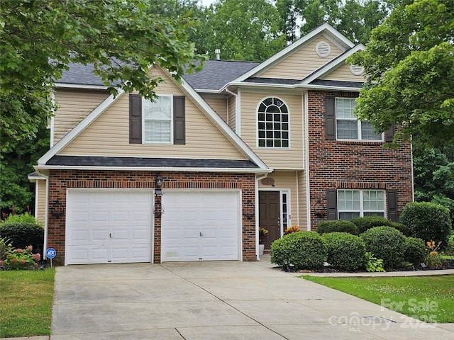 935 Wind Carved Ln, Monroe, NC 28110 - traditional home with driveway, a garage, brick siding, and a shingled roof