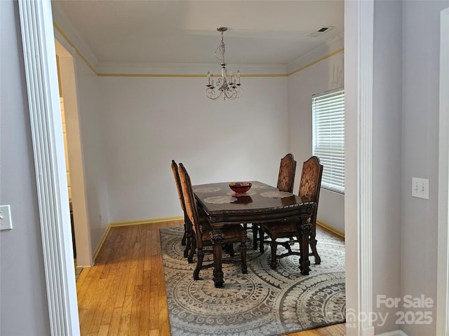 935 Wind Carved Ln, Monroe, NC 28110 - dining space with ornamental molding, a chandelier, and light wood-style flooring