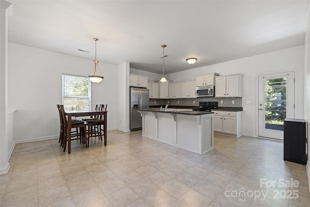 1287 Century Dr, Clover, SC 29710 - kitchen with appliances with stainless steel finishes, dark countertops, plenty of natural light, and a breakfast bar area