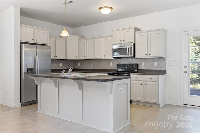 1287 Century Dr, Clover, SC 29710 - kitchen featuring appliances with stainless steel finishes, tasteful backsplash, an island with sink, and pendant lighting