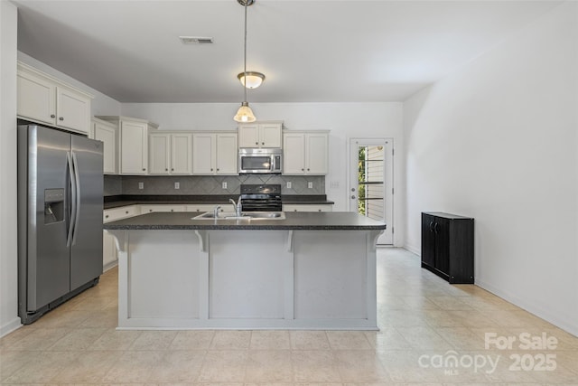 1287 Century Dr, Clover, SC 29710 - kitchen featuring stainless steel appliances, dark countertops, backsplash, decorative light fixtures, and white cabinetry