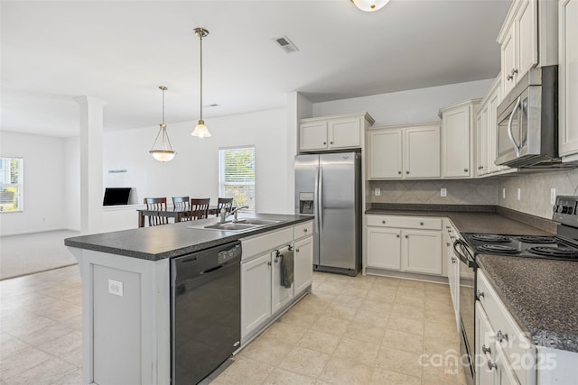 1287 Century Dr, Clover, SC 29710 - kitchen featuring black appliances, dark countertops, healthy amount of natural light, and a kitchen island with sink