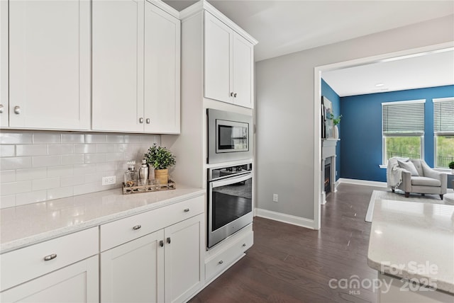 2225 Masons Bend Dr, Fort Mill, SC 29708 - kitchen with appliances with stainless steel finishes, dark wood-style floors, decorative backsplash, white cabinetry, and light stone countertops