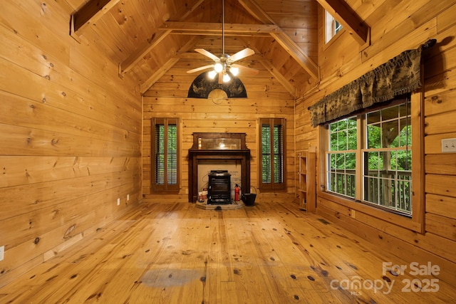 41 Waya Way, Whittier, NC 28789 - unfurnished living room featuring a wood stove, wood walls, hardwood / wood-style floors, ceiling fan, and a wooden ceiling with exposed beams