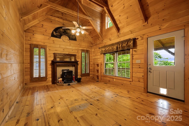 41 Waya Way, Whittier, NC 28789 - unfurnished living room featuring a wood stove, wooden walls, hardwood / wood-style floors, ceiling fan, and high vaulted ceiling