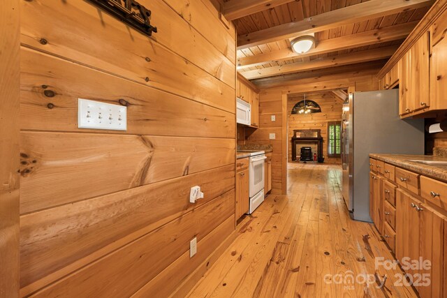 41 Waya Way, Whittier, NC 28789 - kitchen featuring white appliances, wood walls, a wood ceiling with exposed beams, light wood-type flooring, and a fireplace with raised hearth