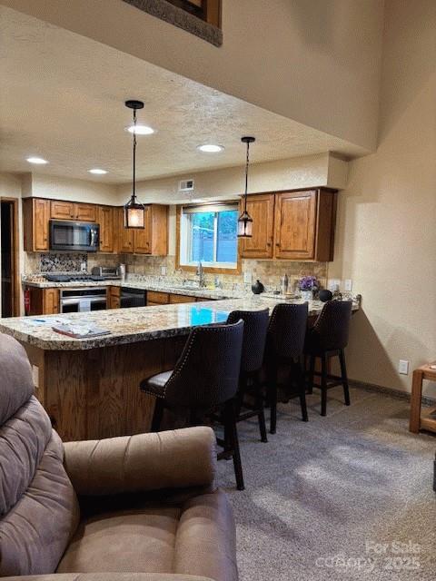 535 Lafayette Pl, Carthage, NC 28327 - kitchen with black appliances, open floor plan, a peninsula, a breakfast bar area, and brown cabinets