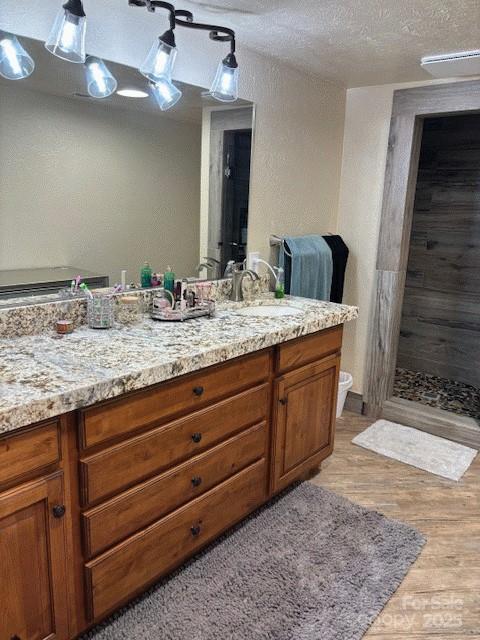535 Lafayette Pl, Carthage, NC 28327 - full bath featuring vanity, wood finished floors, tiled shower, and a textured ceiling