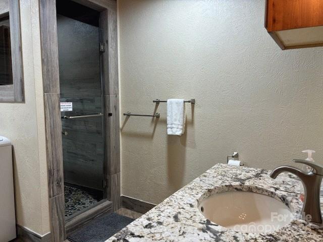 535 Lafayette Pl, Carthage, NC 28327 - bathroom featuring a stall shower, washer / dryer, and vanity