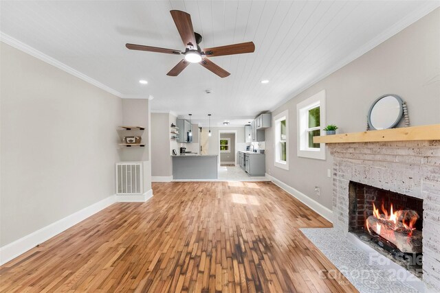 410 Gann St, Lowell, NC 28098 - unfurnished living room with light wood-style flooring, a fireplace with flush hearth, ceiling fan, ornamental molding, and recessed lighting