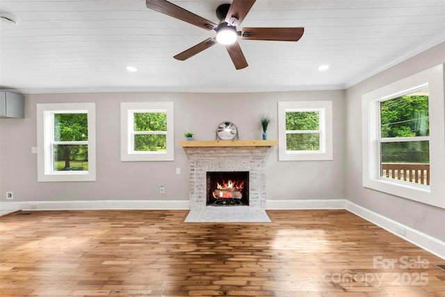 410 Gann St, Lowell, NC 28098 - unfurnished living room with ornamental molding, plenty of natural light, a fireplace, light wood-style floors, and a ceiling fan