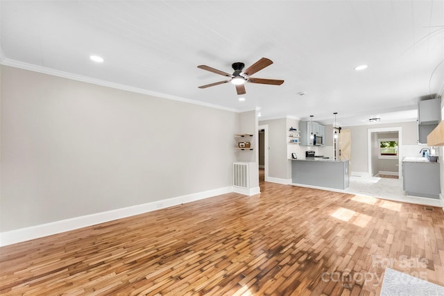 410 Gann St, Lowell, NC 28098 - unfurnished living room with light wood-style flooring, a ceiling fan, crown molding, and recessed lighting