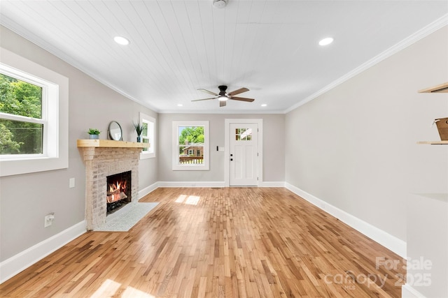 410 Gann St, Lowell, NC 28098 - unfurnished living room featuring plenty of natural light, recessed lighting, light wood finished floors, a fireplace with flush hearth, and crown molding
