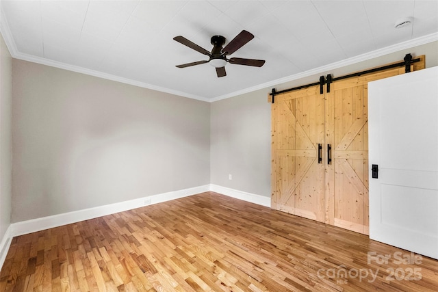 410 Gann St, Lowell, NC 28098 - spare room featuring ceiling fan, wood finished floors, a barn door, and ornamental molding