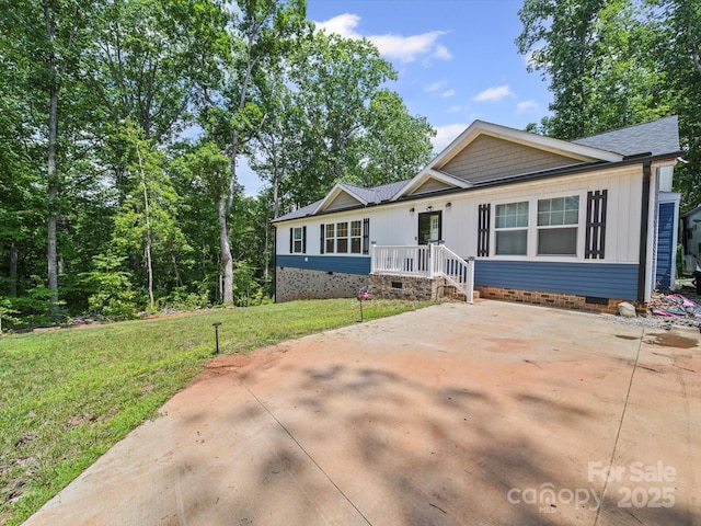 601 Lhasa Apso Ln, Iron Station, NC 28080 - view of front of home with crawl space, a front lawn, a shingled roof, and board and batten siding