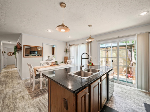 601 Lhasa Apso Ln, Iron Station, NC 28080 - kitchen with a textured ceiling, dark countertops, pendant lighting, black microwave, and light wood-style floors