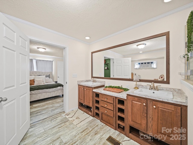 601 Lhasa Apso Ln, Iron Station, NC 28080 - full bathroom with double vanity, wood finished floors, connected bathroom, ornamental molding, and a textured ceiling