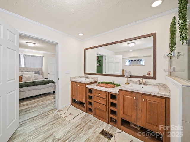 601 Lhasa Apso Ln, Iron Station, NC 28080 - ensuite bathroom featuring double vanity, wood finished floors, crown molding, a textured ceiling, and recessed lighting