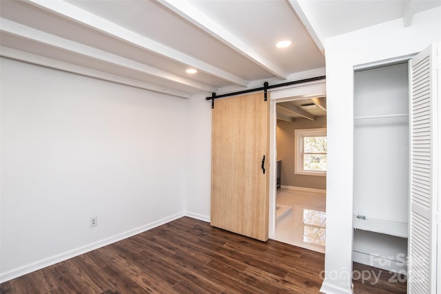 678 Wagner St, Troutman, NC 28166 - unfurnished bedroom with a barn door, beam ceiling, dark wood-type flooring, and recessed lighting