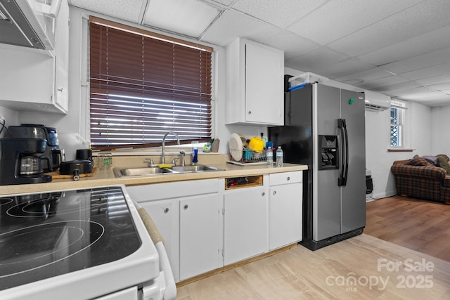 306 Forest Ave, Franklin, NC 28734 - kitchen with stainless steel fridge with ice dispenser, an AC wall unit, light wood-type flooring, white cabinets, and light countertops
