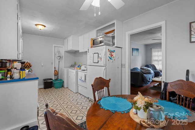 306 Forest Ave, Franklin, NC 28734 - kitchen with freestanding refrigerator, washing machine and clothes dryer, a ceiling fan, white cabinets, and stainless steel microwave