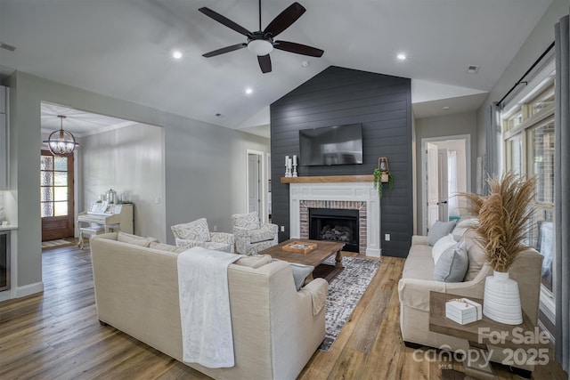 2545 10th Street Ct NE, Hickory, NC 28601 - living room with ceiling fan, vaulted ceiling, wood finished floors, a brick fireplace, and a chandelier
