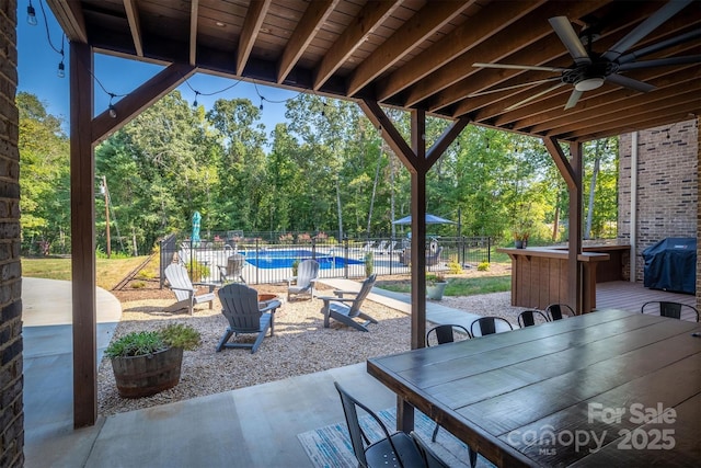 2545 10th Street Ct NE, Hickory, NC 28601 - view of patio featuring grilling area, outdoor dining space, ceiling fan, and view of wooded area