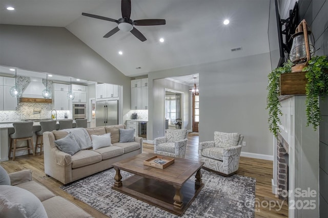 2545 10th Street Ct NE, Hickory, NC 28601 - living area with beverage cooler, high vaulted ceiling, ceiling fan, light wood-style floors, and a brick fireplace