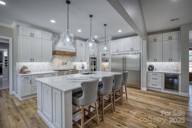 2545 10th Street Ct NE, Hickory, NC 28601 - kitchen with appliances with stainless steel finishes, beverage cooler, tasteful backsplash, premium range hood, and white cabinetry