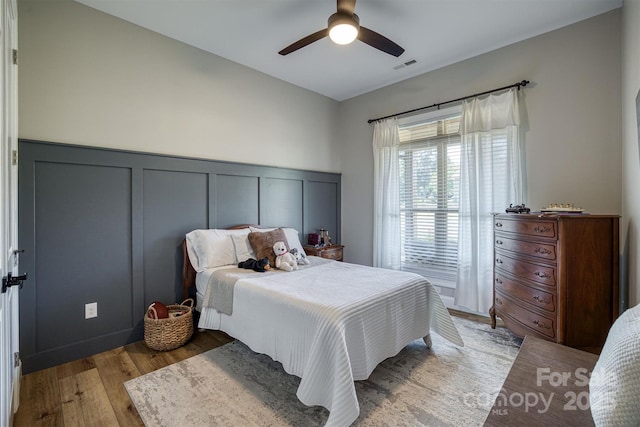 2545 10th Street Ct NE, Hickory, NC 28601 - bedroom with a decorative wall, wood finished floors, a wainscoted wall, and ceiling fan