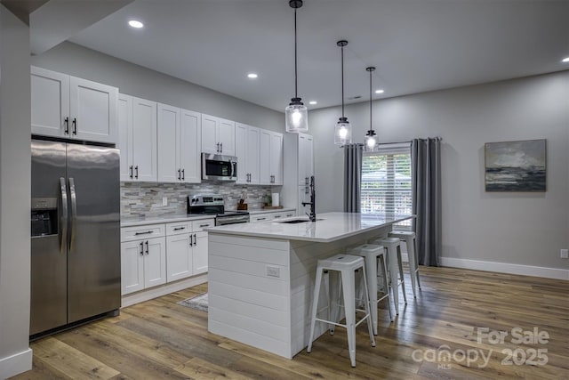 2545 10th Street Ct NE, Hickory, NC 28601 - kitchen featuring stainless steel appliances, a center island with sink, wood finished floors, tasteful backsplash, and recessed lighting